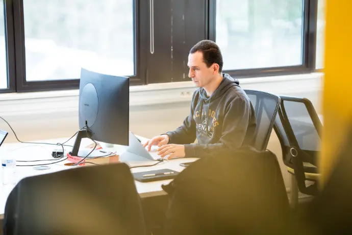 Homme travaillant sur son projet devant un écran d'ordinateur